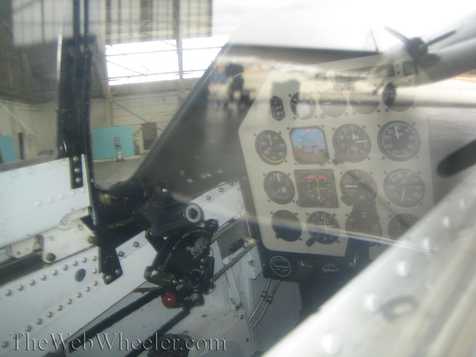 Close-up of aircraft cockpit instrument panel with gauges seen through canopy