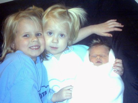 2002 Oldsmobile Aurora - A family portrait captures three young children, including a newborn, sharing a tender moment.