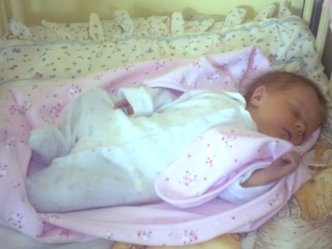 2002 Oldsmobile Aurora - A peaceful scene of a newborn baby sleeping in a crib, adorned with floral-patterned blankets.
