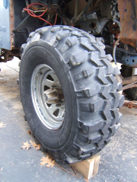 1980 Jeep CJ5 - A 1980 Jeep CJ5 is viewed from the side, highlighting its off-road tire and the exposed mechanicals of its engine bay.