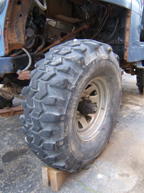 1980 Jeep CJ5 - Close-up of a Jeep's front wheel and fender, showing a large off-road tire mounted on a silver rim.