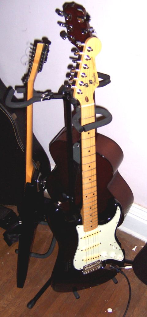 1978 Ford Bronco - Guitars on stands, including a black electric and an acoustic guitar.