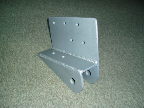 1994 Ford Bronco - A close-up view of a fabricated metal bracket with several drilled holes.