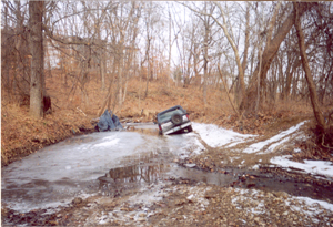 1982 Ford Bronco - This 1982 Ford Bronco is stuck in a muddy, icy trail surrounded by bare trees.