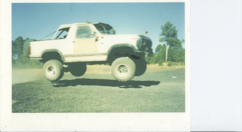 1993 Ford F-150 - White Ford Bronco airborne during a jump, its off-road capabilities.