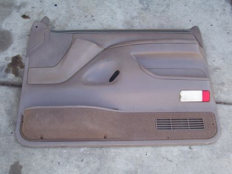 1991 Ford Bronco - A detached car door panel is shown lying on a concrete surface.