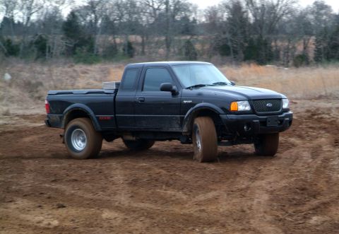 1995 Ford Bronco - This black Ford Ranger pickup truck, likely from the early 2000s, is shown navigating a muddy terrain.