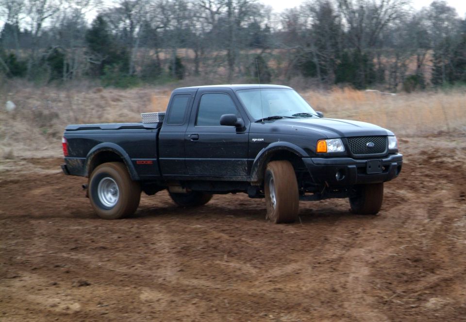 Black Ford Ranger pickup truck with "EDGE" badging on the side, driving off-road