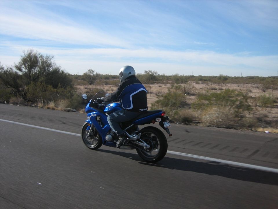 Blue 2007 Kawasaki Ninja motorcycle seen from the side on a highway