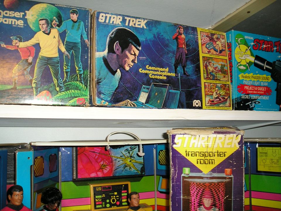 Several vintage Star Trek toy boxes and playsets on shelves, including a 'Command Communications Console' box