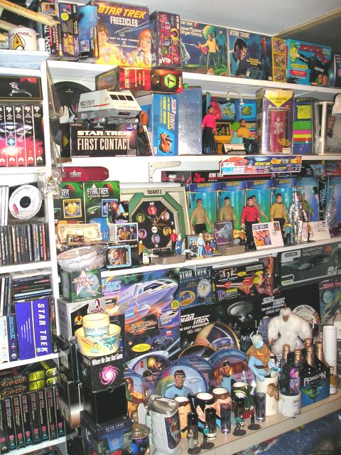 1966 Pontiac Fiero - A collection of Star Trek merchandise, including action figures, model ships, and DVDs, is displayed on shelves.