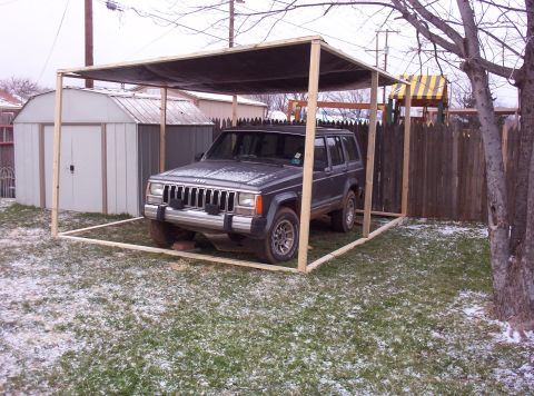 1987 Jeep Cherokee - This 1987 Jeep Cherokee is parked under a temporary wooden shelter in a yard with patchy snow.