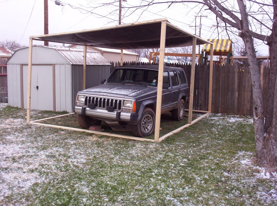 1987 Jeep Cherokee parked under a makeshift wooden carport