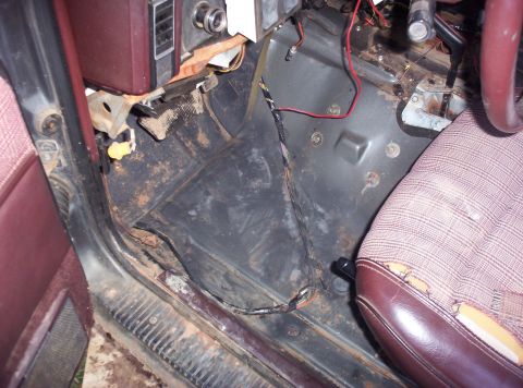 1987 Jeep Cherokee - The interior floor and worn seat of a 1987 Jeep Cherokee show signs of age and use.