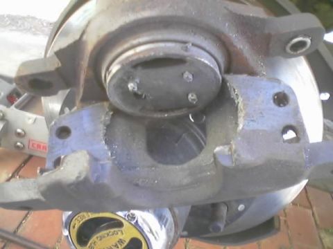 1989 Ford Bronco - Close-up view of a vehicle's brake caliper and rotor assembly, with a yellow warning sticker visible.