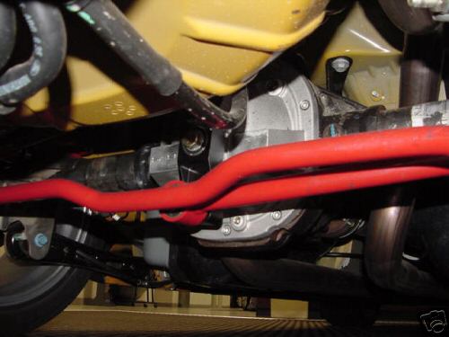Rear axle and red suspension components on a yellow vehicle