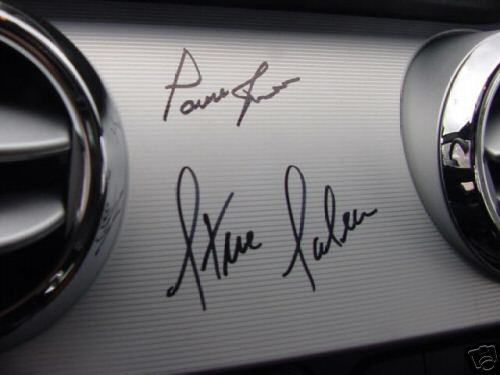 Dashboard trim with two signatures, one above the other. Chrome air vents on left and right