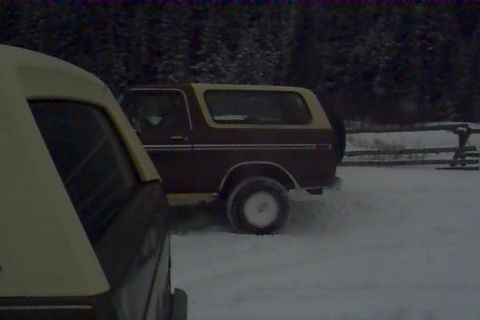 1980 Ford Bronco - Ford Bronco in a snowy landscape with another vehicle in the foreground.