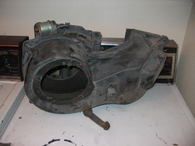 Black plastic HVAC blower motor housing with metal actuator rod and electrical connector