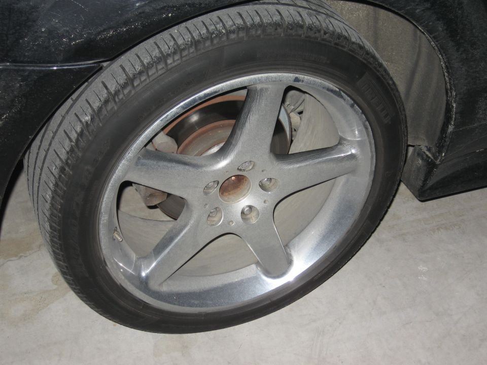 Close-up of a five-spoke alloy wheel and tire on a black vehicle