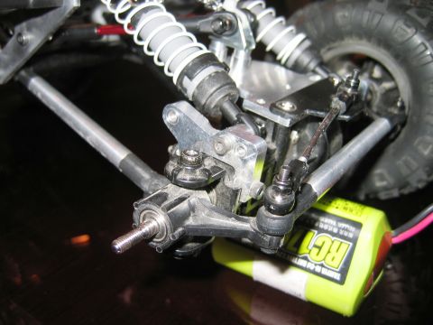 1985 Ford Bronco - The intricate suspension system of a radio-controlled vehicle is shown, with a Tamiya battery pack in view.