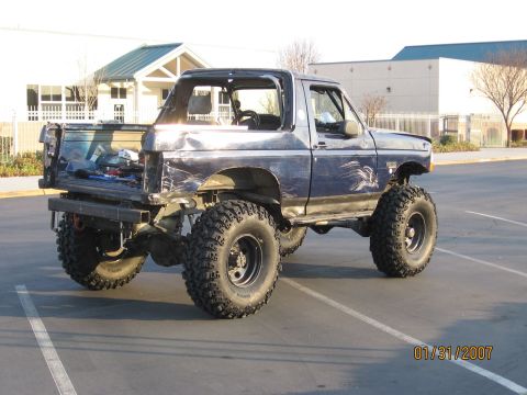 1994 Ford Bronco - This modified 1994 Ford Bronco features a lifted suspension, large off-road tires, and a custom rear bumper, suggesting it's built for terr…