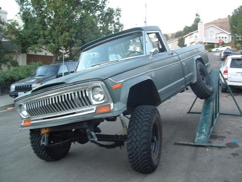 1977 Jeep J-10 - This 1977 Jeep J-10 pickup truck is shown with a lifted suspension, positioned on an incline ramp.