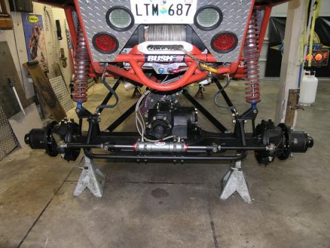 1974 Ford F-100 - The underside of a custom off-road vehicle is shown, lifted on jack stands for maintenance.