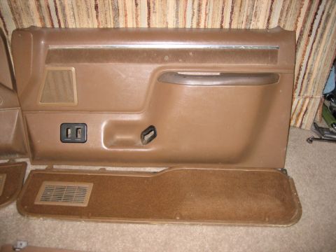 1990 Ford Bronco - Brown door panels, likely from a Ford Bronco, are shown laid out for inspection.