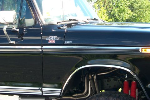 1979 Ford F-250 - This black 1979 Ford F-250 Ranger XLT features custom exhaust pipes visible under the fender.