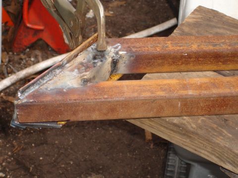 1989 Ford Bronco - Metal fabrication in progress, showing welded tubes and a clamp.