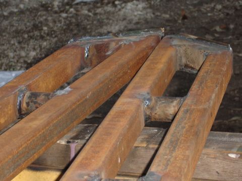 1989 Ford Bronco - Custom metal sliders, likely for an off-road vehicle, show signs of rust and welding.