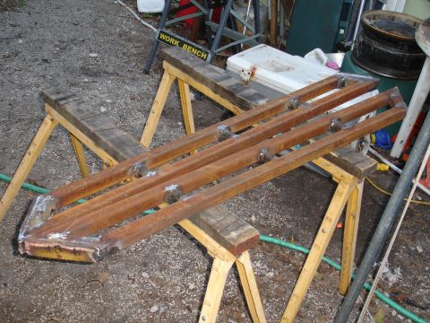 1989 Ford Bronco - Custom metal sliders are shown resting on sawhorses in a workshop setting.