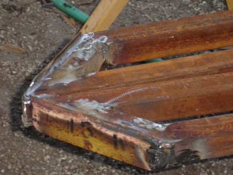 1989 Ford Bronco - Close-up view of rusted metal sliders, showing welds and some handwritten markings.