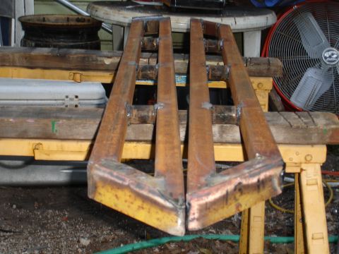 1989 Ford Bronco - Welded metal sliders are shown resting on sawhorses, with a fan visible in the background.