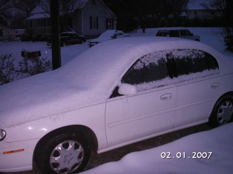 1996 Ford Bronco - A white sedan sits covered in snow, with other vehicles visible in the background. The photo is dated February 1, 2007.