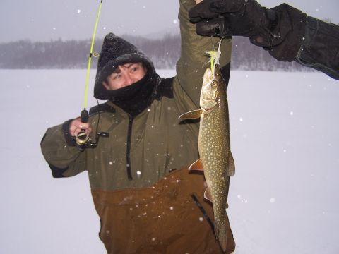 1979 Chevrolet Blazer - A person proudly displays a fish caught while ice fishing in a snowy landscape.