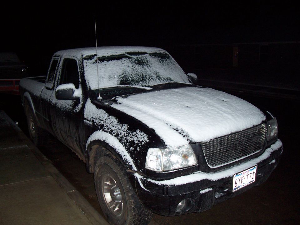 Black pickup truck in snow with visible license plate BYF-771