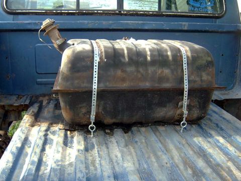 1988 Ford F-250 - An auxiliary fuel tank is secured in the bed of a blue pickup truck with metal straps.