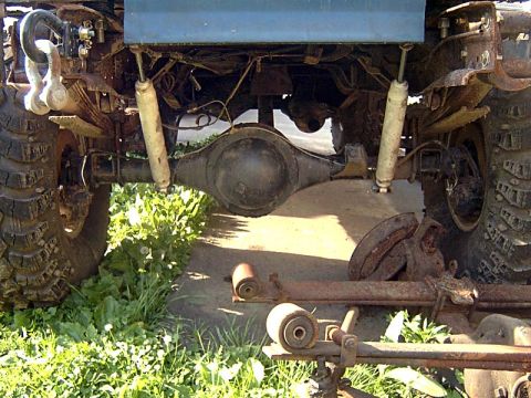 1988 Ford F-250 - Close-up view of the rear axle and suspension of a heavily modified off-road vehicle.