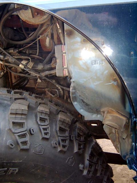1988 Ford F-250 - Detail of a truck's wheel well and engine bay, with visible modifications to the fender.