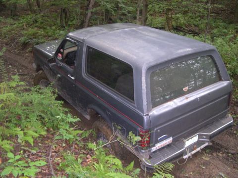 1989 Ford Bronco - This 1989 Ford Bronco navigates a muddy trail through a wooded area.