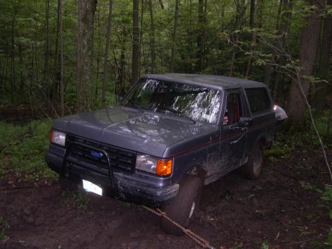 1989 Ford Bronco - Ford Bronco stuck in the mud in a wooded area.