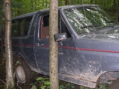 1989 Ford Bronco - This 1989 Ford Bronco is stuck deep in the mud and trees off-road.