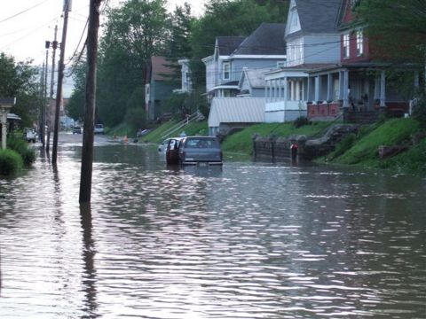 1989 Ford Bronco - Street flooding submerges vehicles and encroaches on residential properties.