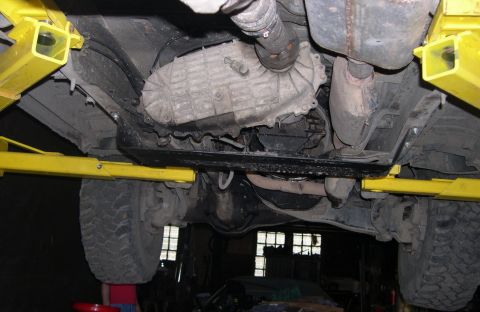 1989 Ford Bronco - Underside view of a vehicle on a lift, focusing on the transmission and exhaust components.