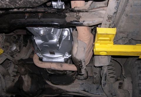 1989 Ford Bronco - Vehicle undercarriage with a focus on the transmission and exhaust components.