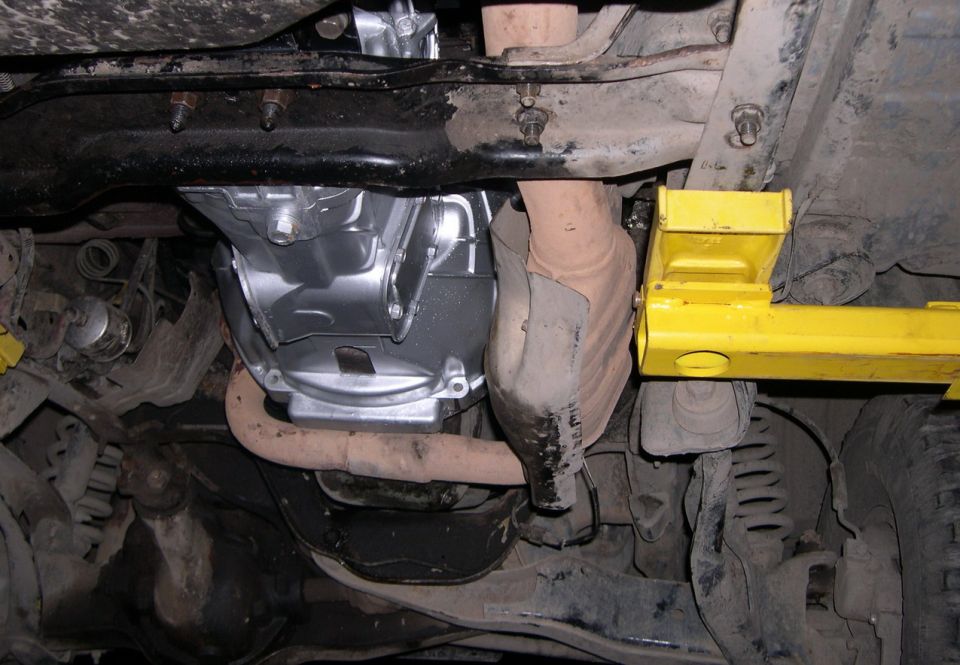 Underbody view of a vehicle showing a newly installed transmission and exhaust system