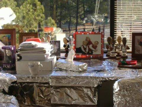 1991 Ford Bronco - A desk is covered in foil and displays family photos and bobbleheads.