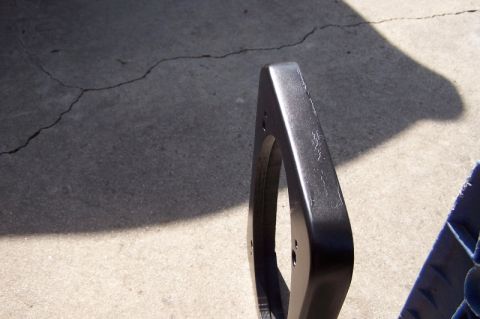 1990 Ford Bronco - A close-up view of a black speaker adapter, likely for a vehicle, resting on a concrete surface.